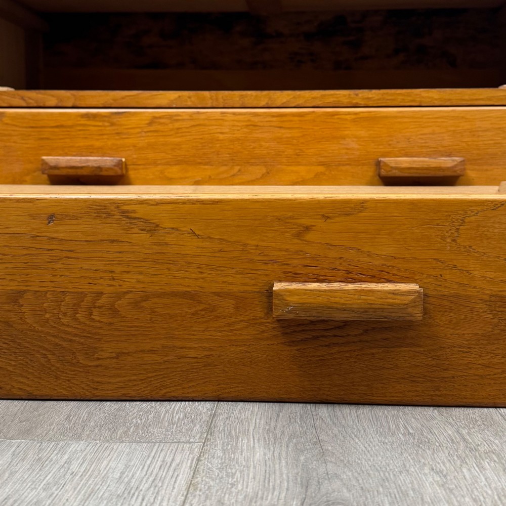 A golden oak chest of four full-width drawers featuring wooden bar handles and a solid plinth base. View XI