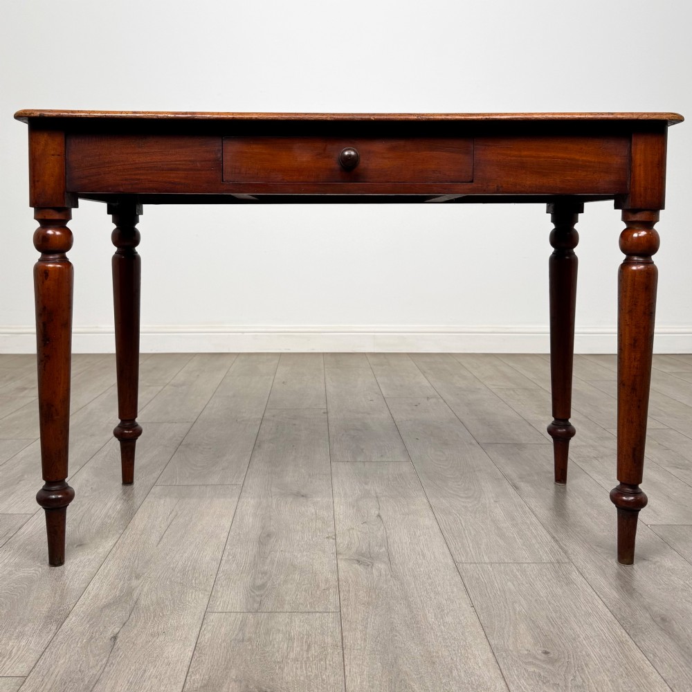 A 19th-century mahogany writing table featuring turned legs and a single frieze drawer with a wooden knob handle.