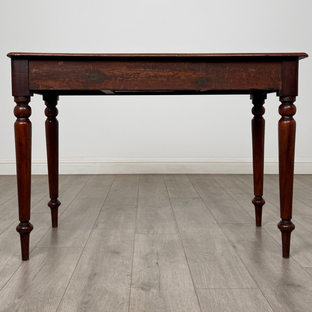 A 19th-century mahogany writing table featuring turned legs and a single frieze drawer with a wooden knob handle. View V