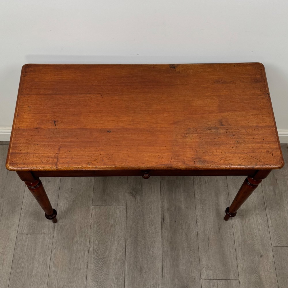 A 19th-century mahogany writing table featuring turned legs and a single frieze drawer with a wooden knob handle. View IX