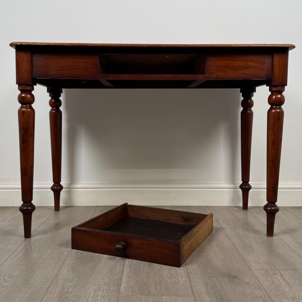 A 19th-century mahogany writing table featuring turned legs and a single frieze drawer with a wooden knob handle. View X