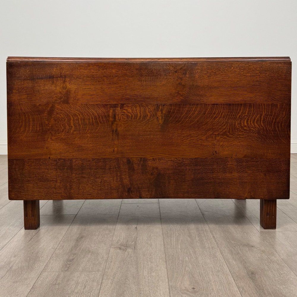 A 20th-century oak drop-leaf table shown with lowered flaps, featuring a single end drawer with a brass drop handle and square legs. View II
