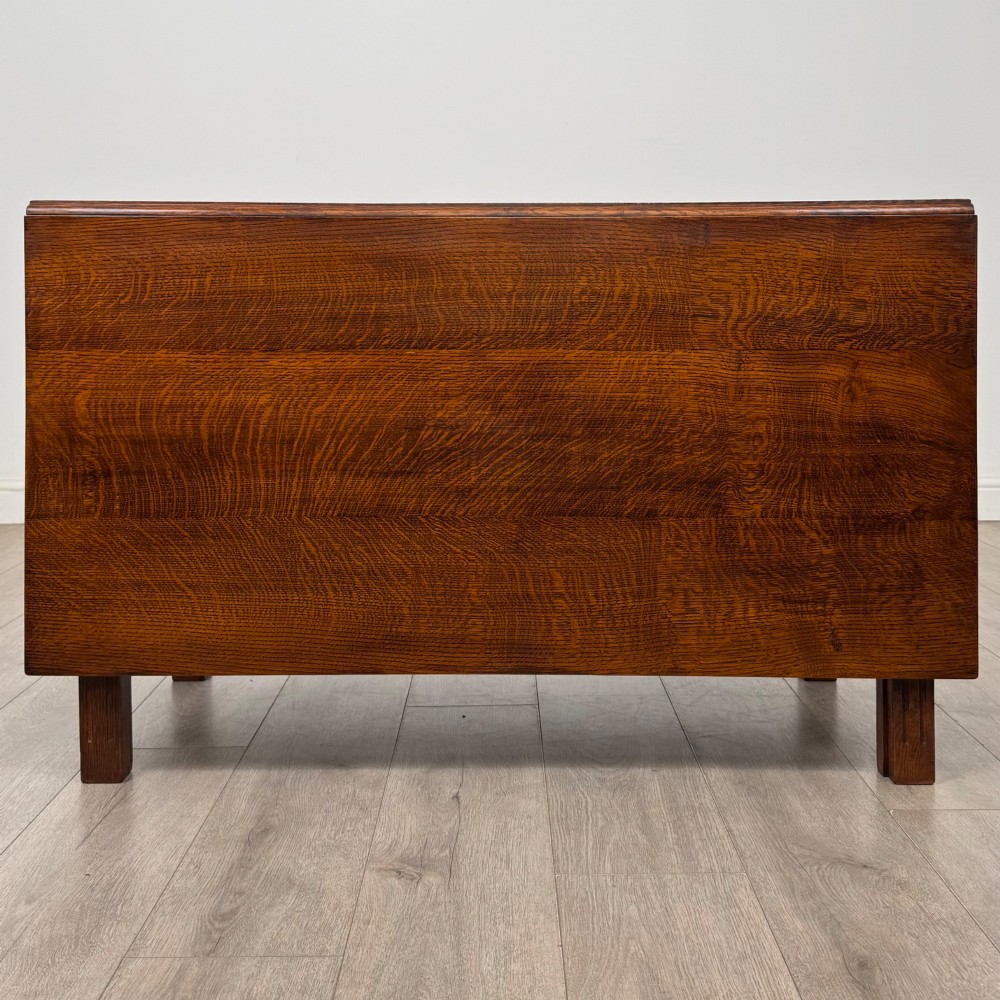 A 20th-century oak drop-leaf table shown with lowered flaps, featuring a single end drawer with a brass drop handle and square legs. View VII