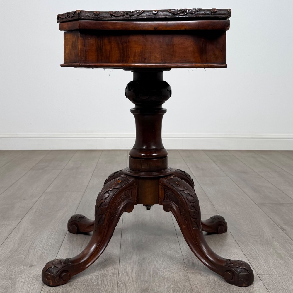 A 19th-century Victorian tea table in figured walnut, showcasing a carved rim, deep apron, turned pedestal, and four acanthus-carved scroll legs. View III