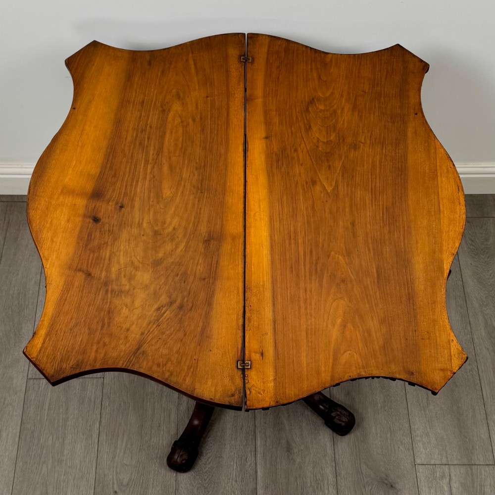 A 19th-century Victorian tea table in figured walnut, showcasing a carved rim, deep apron, turned pedestal, and four acanthus-carved scroll legs. View XI