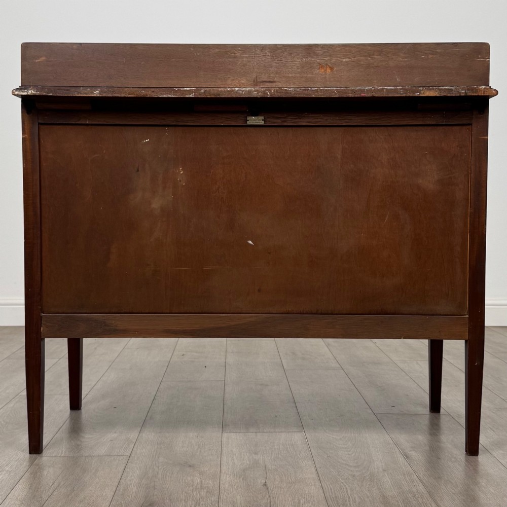 A 20th-century mahogany chest of drawers featuring three straight drawers with string inlay borders, brass ring handles, and square tapered legs. View V