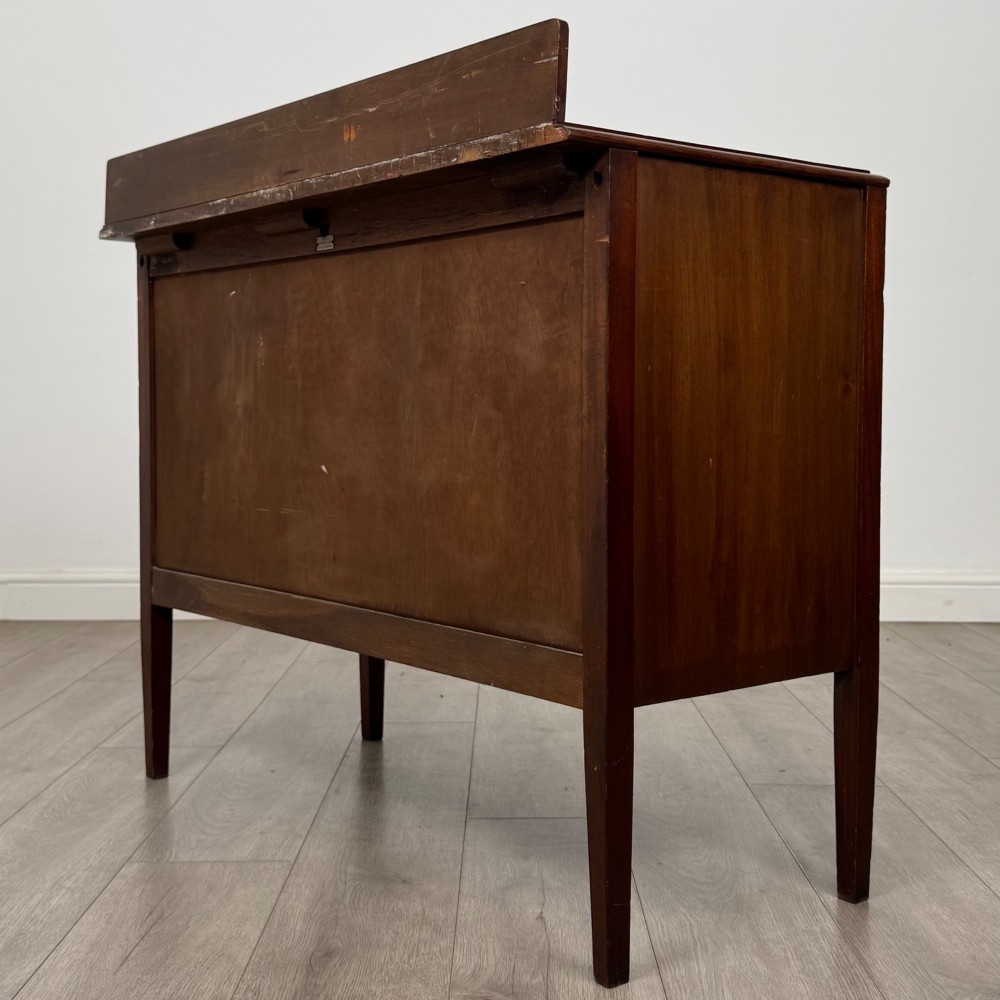 A 20th-century mahogany chest of drawers featuring three straight drawers with string inlay borders, brass ring handles, and square tapered legs. View VI