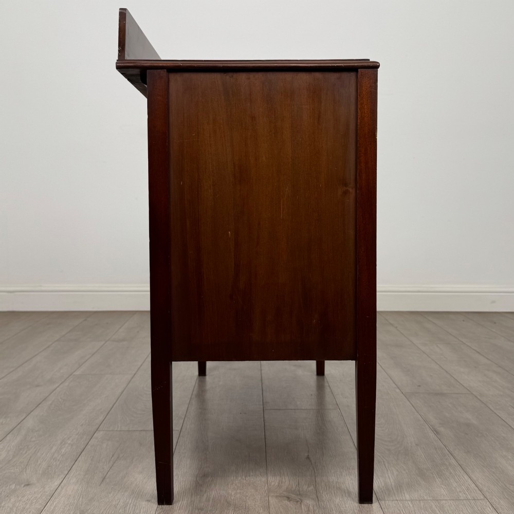 A 20th-century mahogany chest of drawers featuring three straight drawers with string inlay borders, brass ring handles, and square tapered legs. View VII
