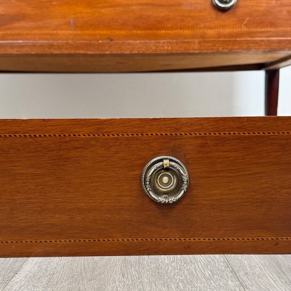 A 20th-century mahogany chest of drawers featuring three straight drawers with string inlay borders, brass ring handles, and square tapered legs. View XI
