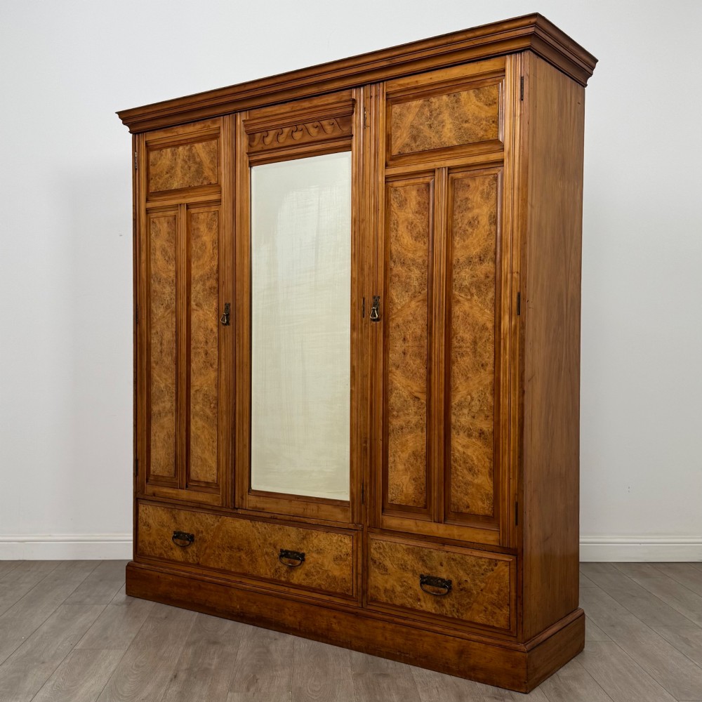 A large Art Deco burr walnut triple wardrobe featuring a central mirror door flanked by two panelled doors over base drawers. View III