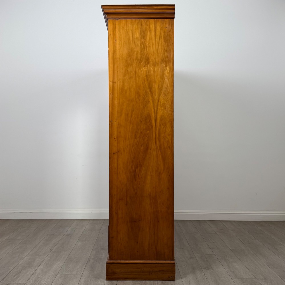 A large Art Deco burr walnut triple wardrobe featuring a central mirror door flanked by two panelled doors over base drawers. View IV