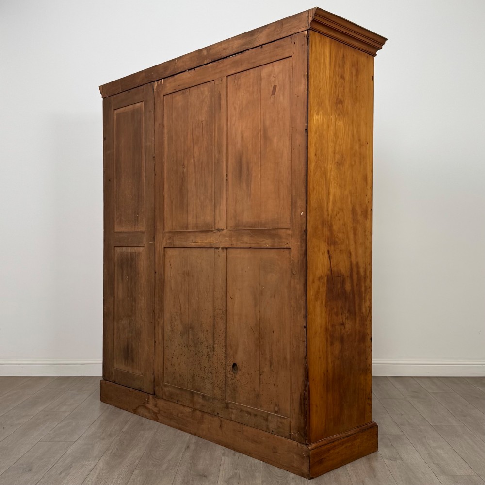 A large Art Deco burr walnut triple wardrobe featuring a central mirror door flanked by two panelled doors over base drawers. View VII