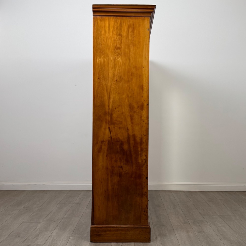 A large Art Deco burr walnut triple wardrobe featuring a central mirror door flanked by two panelled doors over base drawers. View VIII