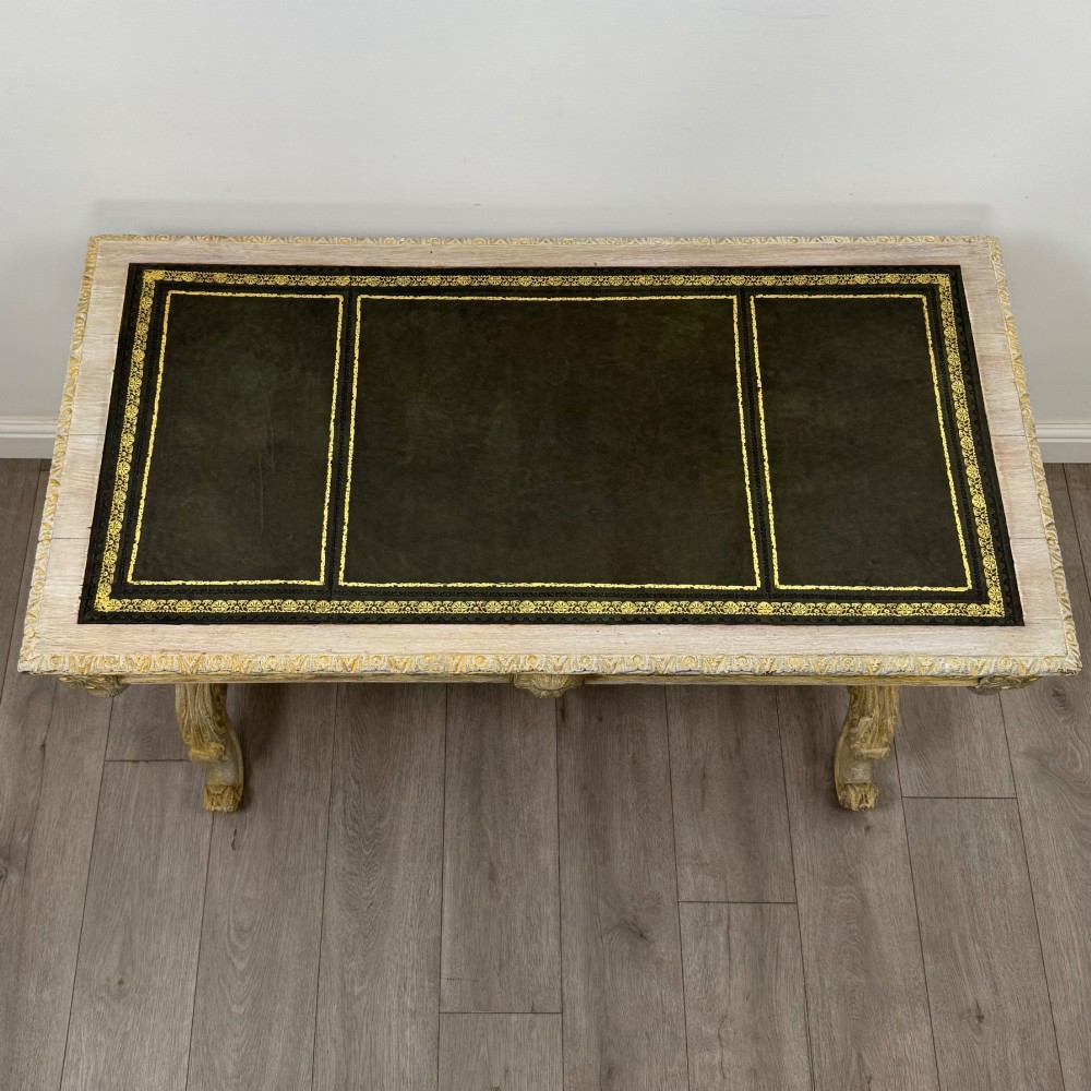 A 19th-century carved oak writing table with spiral barley-twist legs, foliage carving on the drawer frieze, and a weathered grey finish. View IX