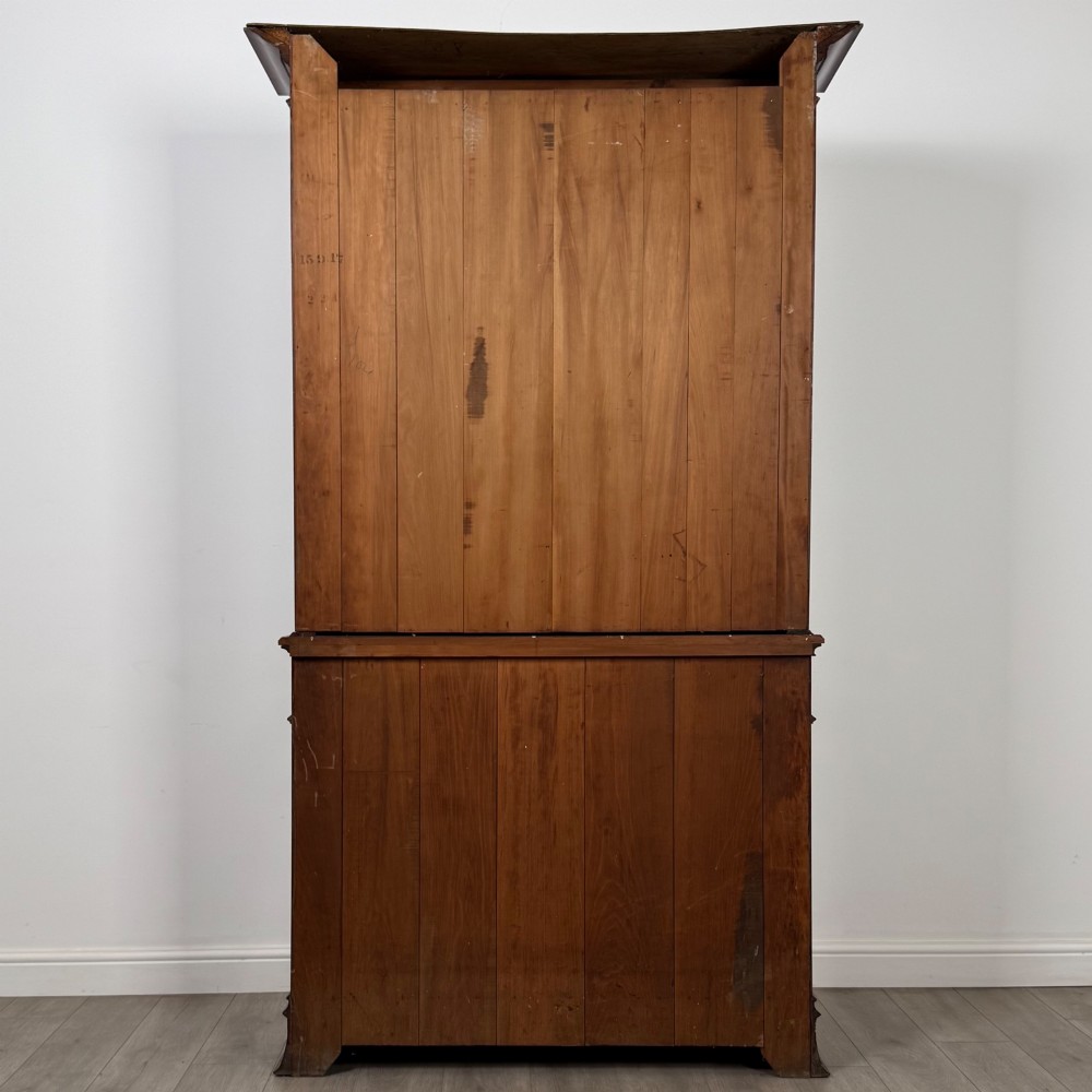 An antique 20th-century mahogany glazed bookcase featuring two upper glass doors, twin middle drawers, and carved lower cupboard doors. View VII