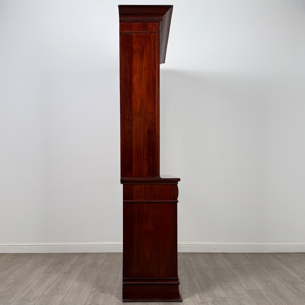 An antique 20th-century mahogany glazed bookcase featuring two upper glass doors, twin middle drawers, and carved lower cupboard doors. View IX