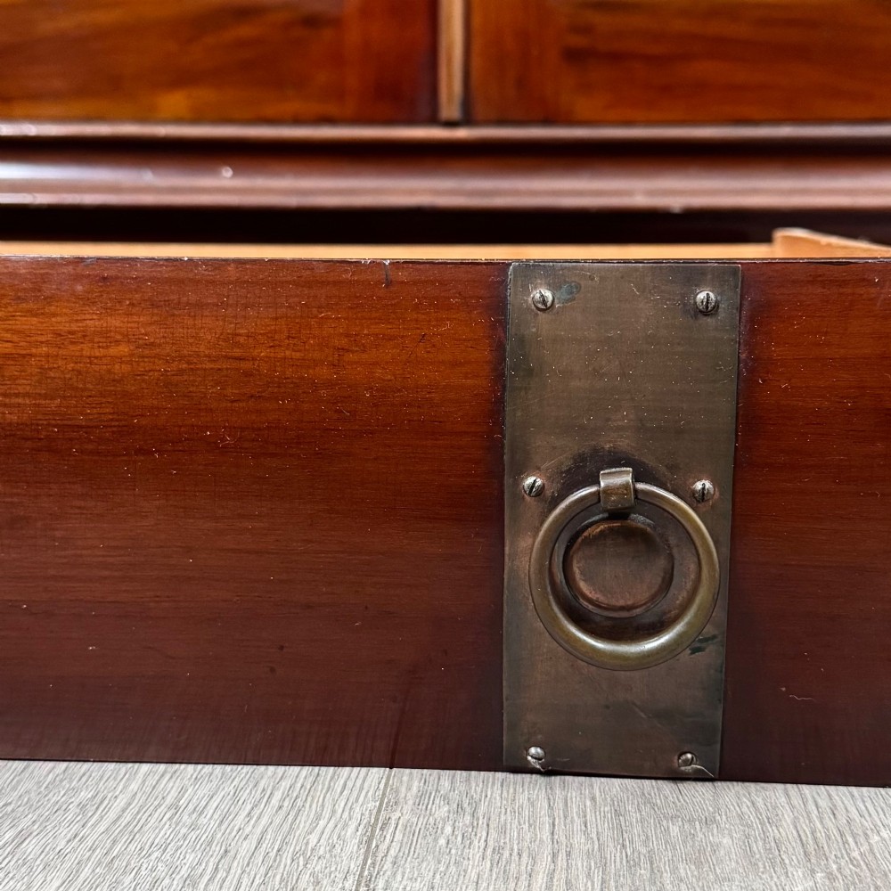 An antique 20th-century mahogany glazed bookcase featuring two upper glass doors, twin middle drawers, and carved lower cupboard doors. View XIII