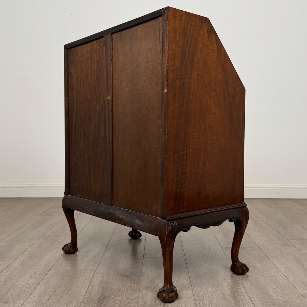 An antique Edwardian figured walnut writing bureau with a slant-front lid, three long drawers, brass handles, and carved cabriole legs on claw-and-ball feet. View VII