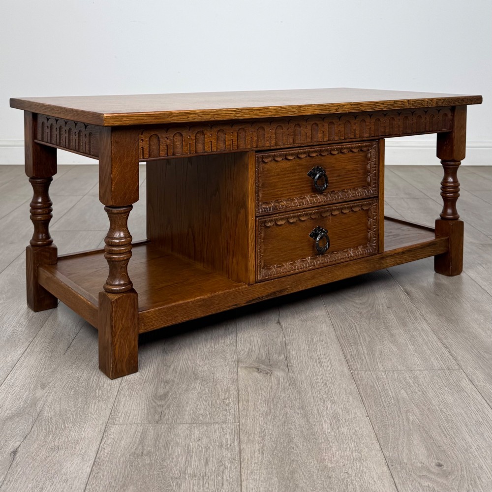 A rectangular carved oak coffee table with two central drawers, metal drop handles, turned legs, and a lower shelf. View VIII
