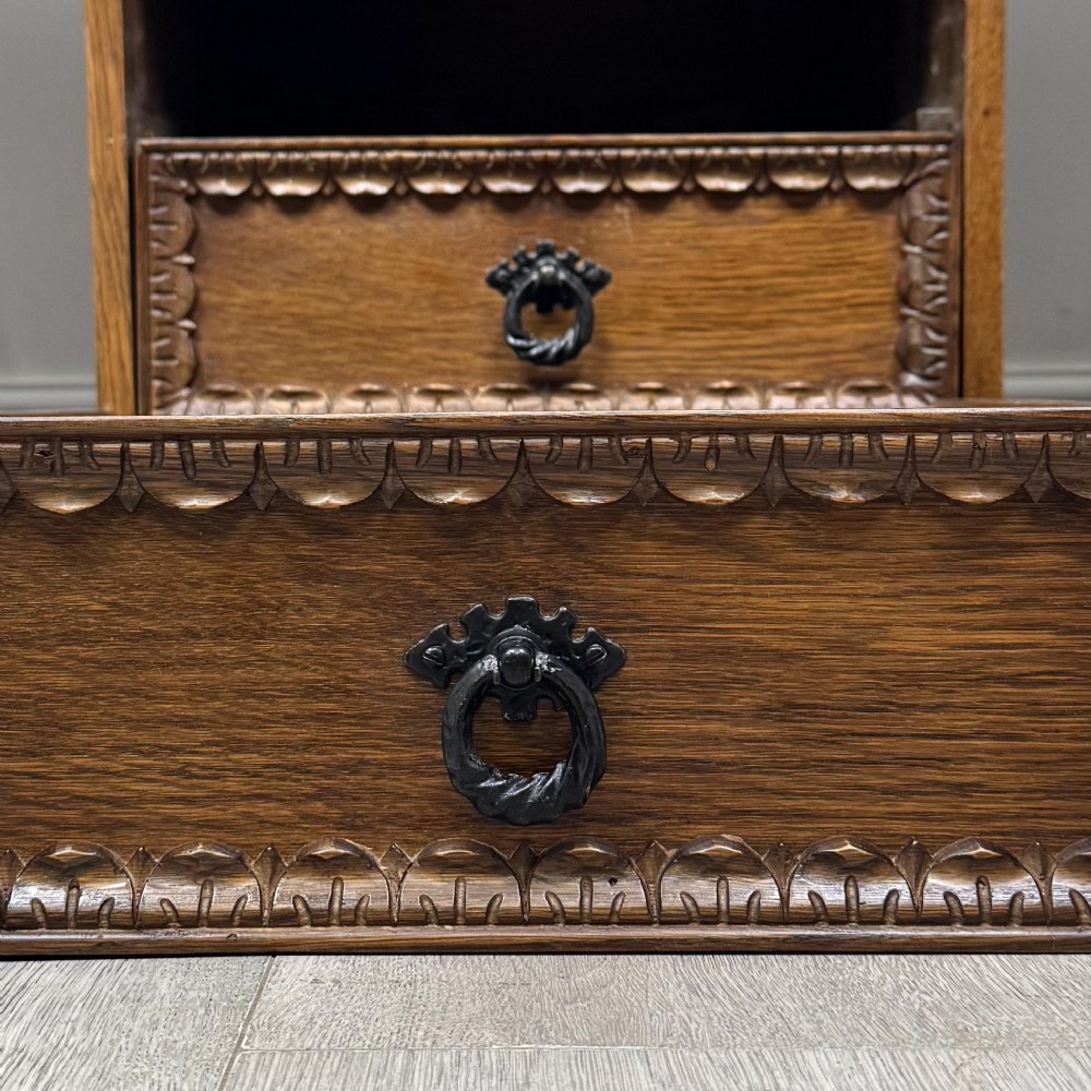 A rectangular carved oak coffee table with two central drawers, metal drop handles, turned legs, and a lower shelf. View XI