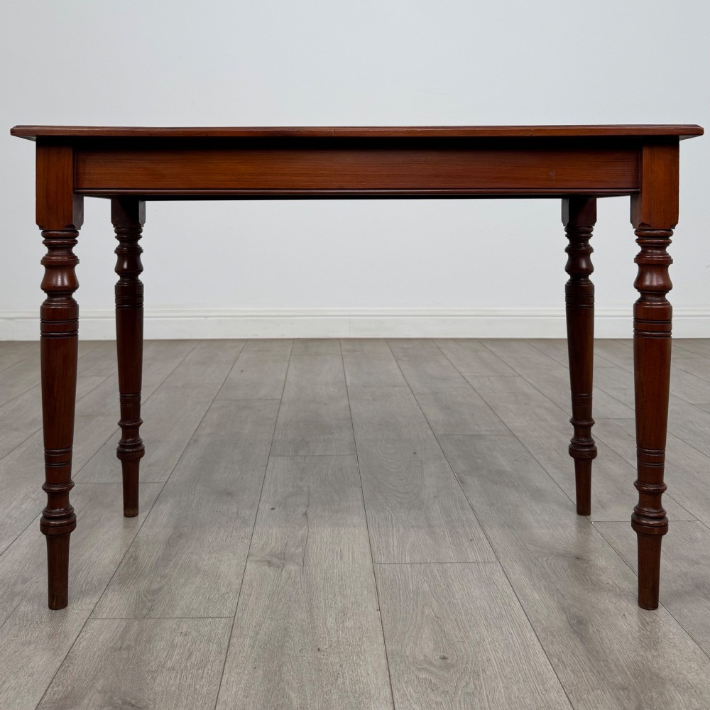 An Edwardian walnut side table featuring a plain rectangular top supported by four detailed turned legs.