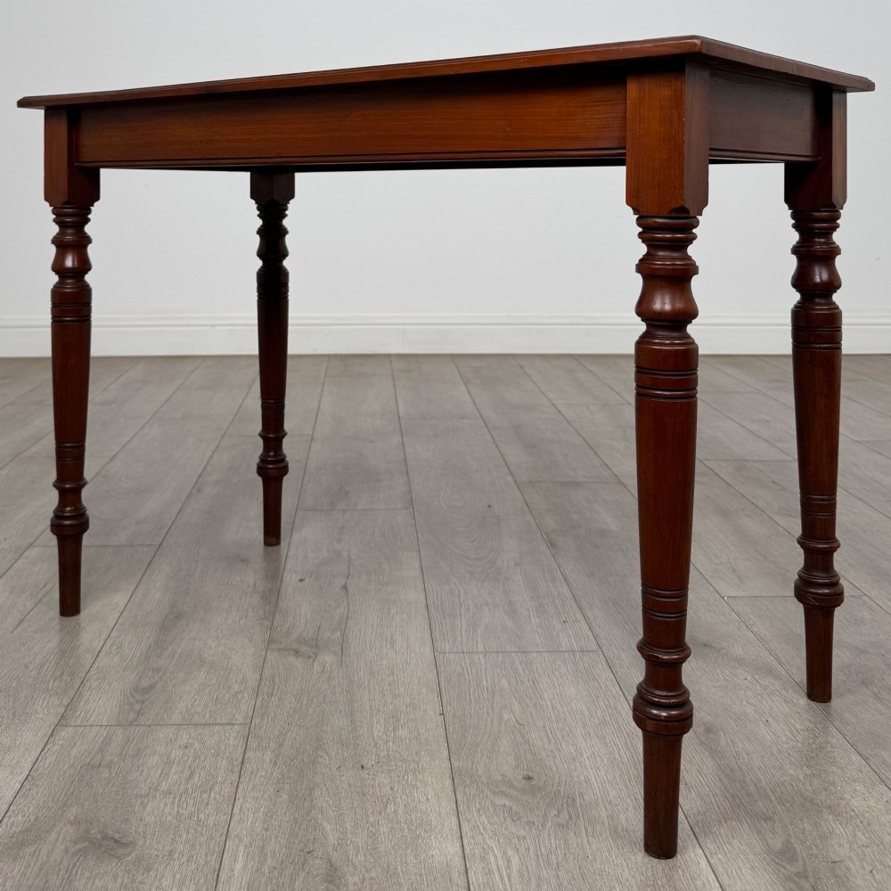 An Edwardian walnut side table featuring a plain rectangular top supported by four detailed turned legs. View II
