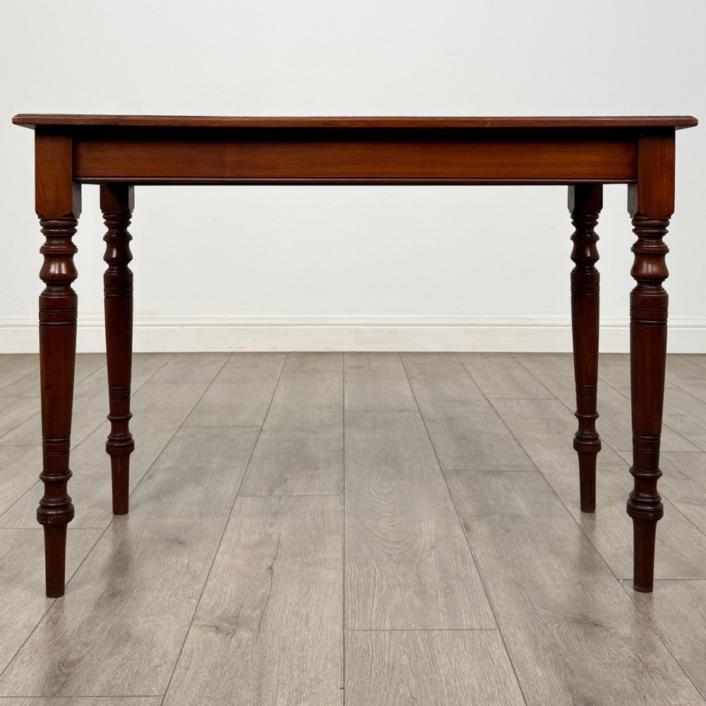 An Edwardian walnut side table featuring a plain rectangular top supported by four detailed turned legs. View V