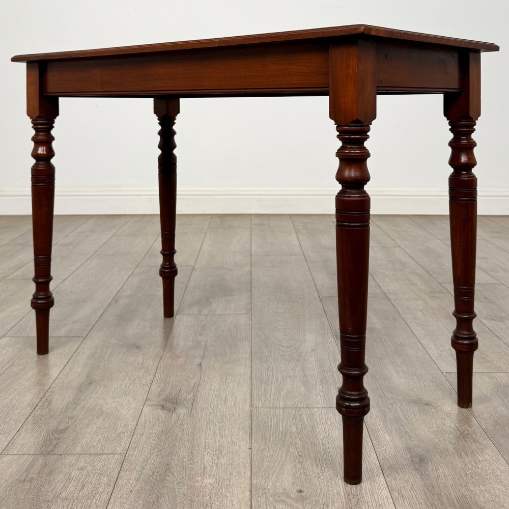 An Edwardian walnut side table featuring a plain rectangular top supported by four detailed turned legs. View VI