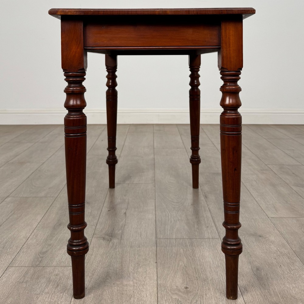 An Edwardian walnut side table featuring a plain rectangular top supported by four detailed turned legs. View VII