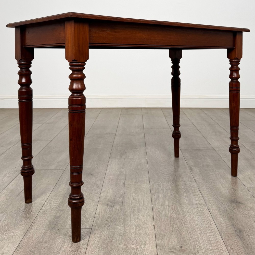 An Edwardian walnut side table featuring a plain rectangular top supported by four detailed turned legs. View VIII