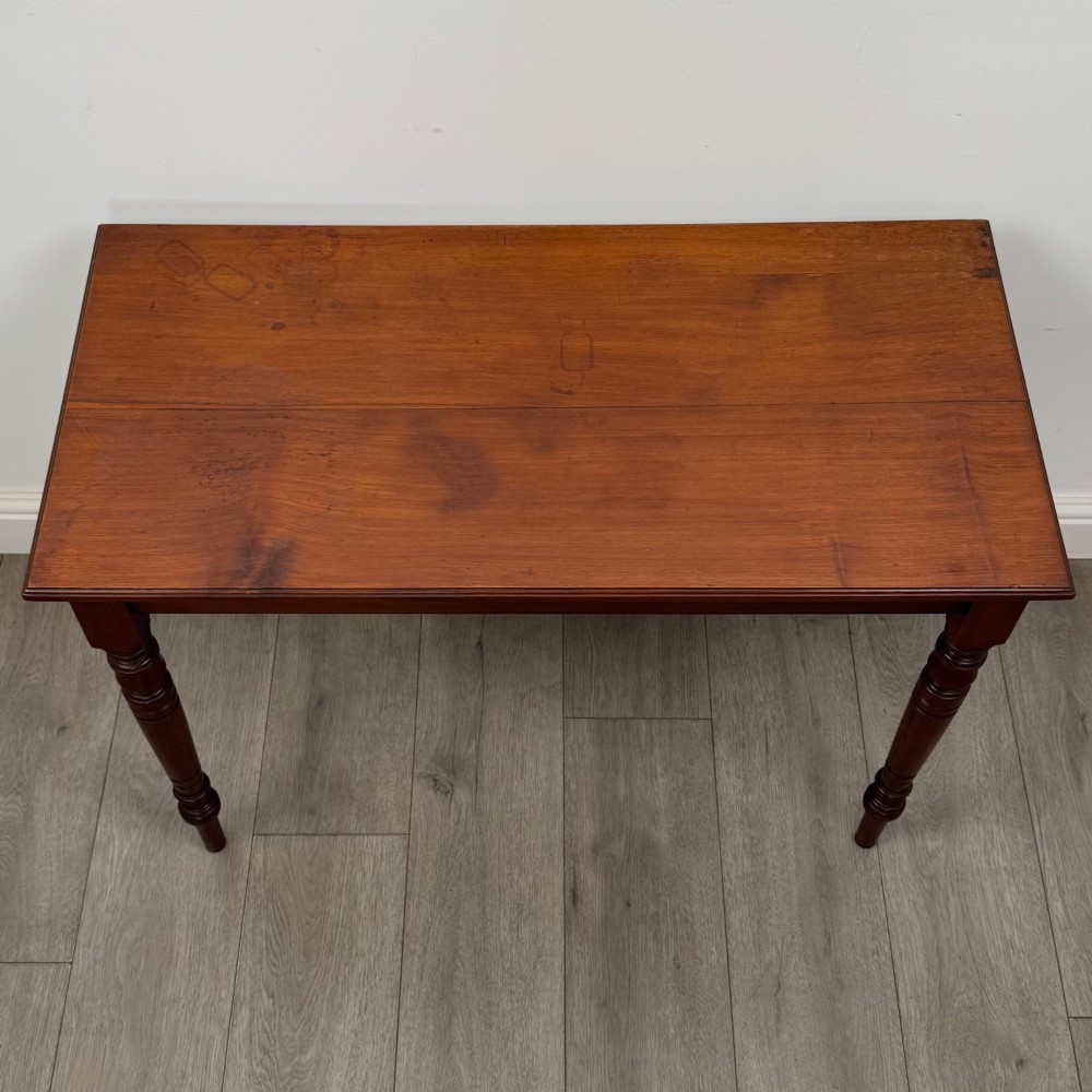An Edwardian walnut side table featuring a plain rectangular top supported by four detailed turned legs. View IX