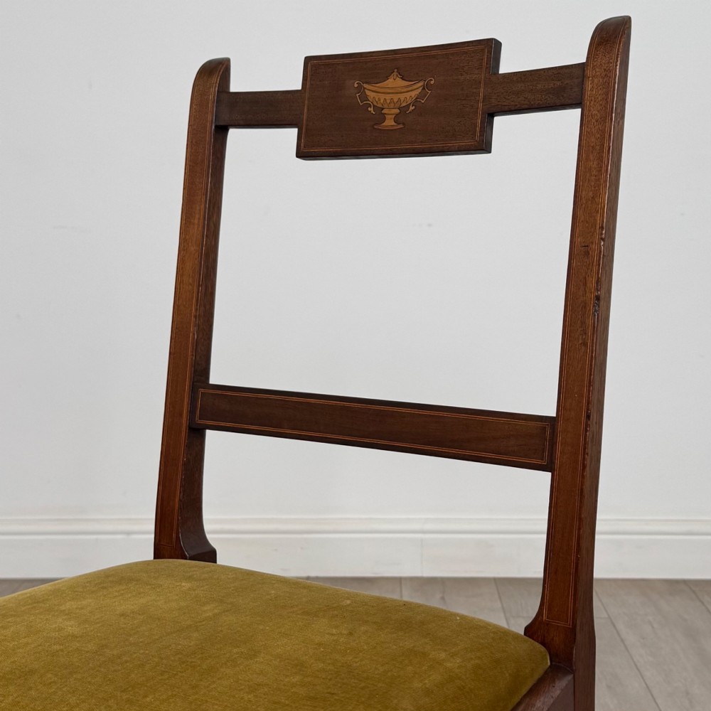 A set of six Georgian mahogany dining chairs featuring open rectangular backs with inlaid urn panels, straight legs with stretchers, and olive green velvet seats. View IV