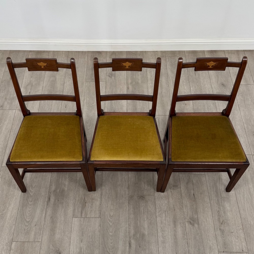 A set of six Georgian mahogany dining chairs featuring open rectangular backs with inlaid urn panels, straight legs with stretchers, and olive green velvet seats. View VII