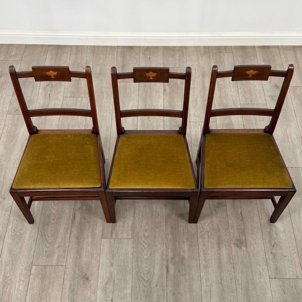 A set of six Georgian mahogany dining chairs featuring open rectangular backs with inlaid urn panels, straight legs with stretchers, and olive green velvet seats. View VIII