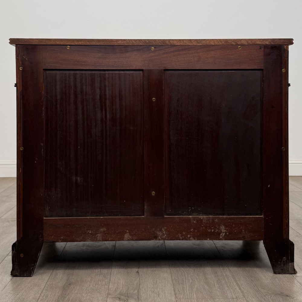 An antique Edwardian mahogany bow-front cupboard featuring two upper drawers with brass handles and two lower doors with oval wood grain panels. View VI