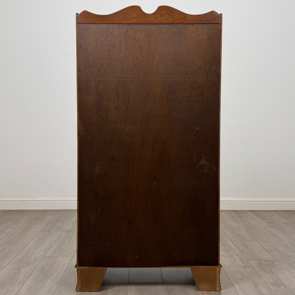 A freestanding dark mahogany waterfall bookcase with four graduated open shelves above two base drawers featuring ring pull handles. View VI