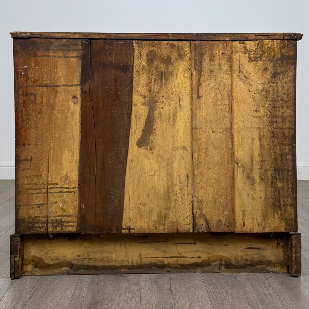 An antique Victorian oak chest of drawers featuring two short top drawers over two long lower drawers with dark drawer fronts, brass oval handles, and a plinth base. View V