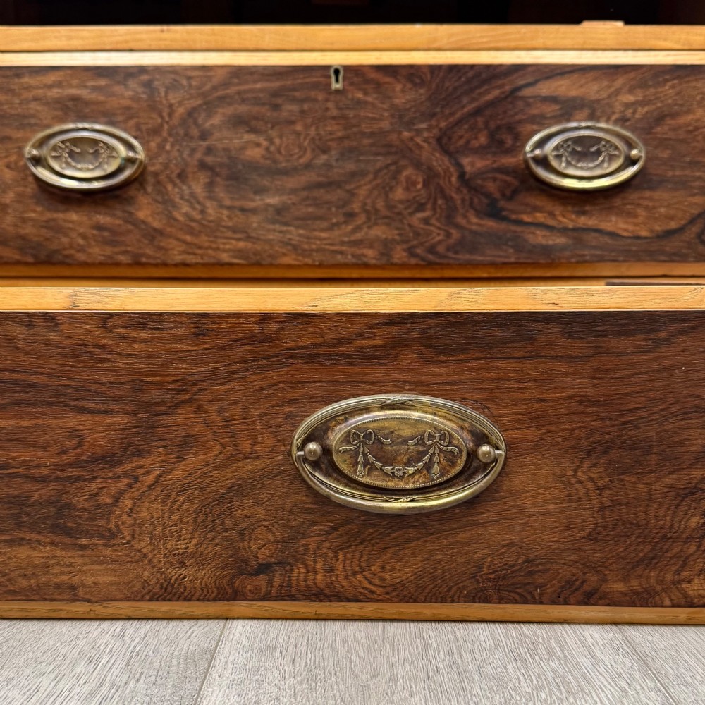 An antique Victorian oak chest of drawers featuring two short top drawers over two long lower drawers with dark drawer fronts, brass oval handles, and a plinth base. View XI