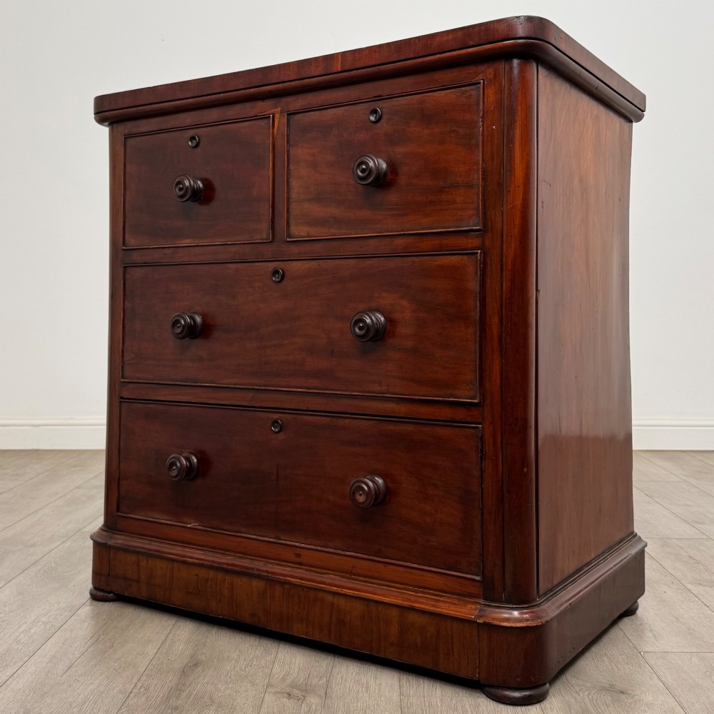 A Victorian dark mahogany chest of drawers featuring two short drawers above two full-width long drawers with turned wooden knobs and a solid plinth base. View II