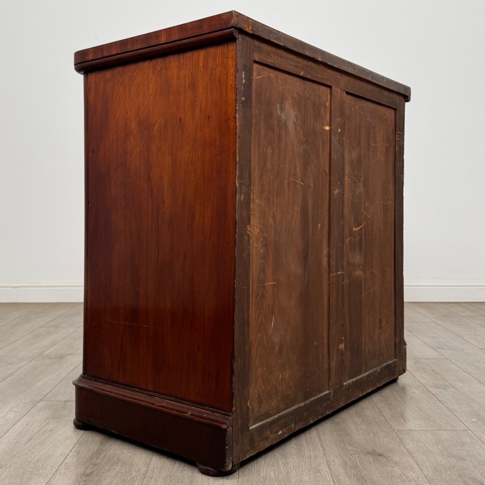 A Victorian dark mahogany chest of drawers featuring two short drawers above two full-width long drawers with turned wooden knobs and a solid plinth base. View IV