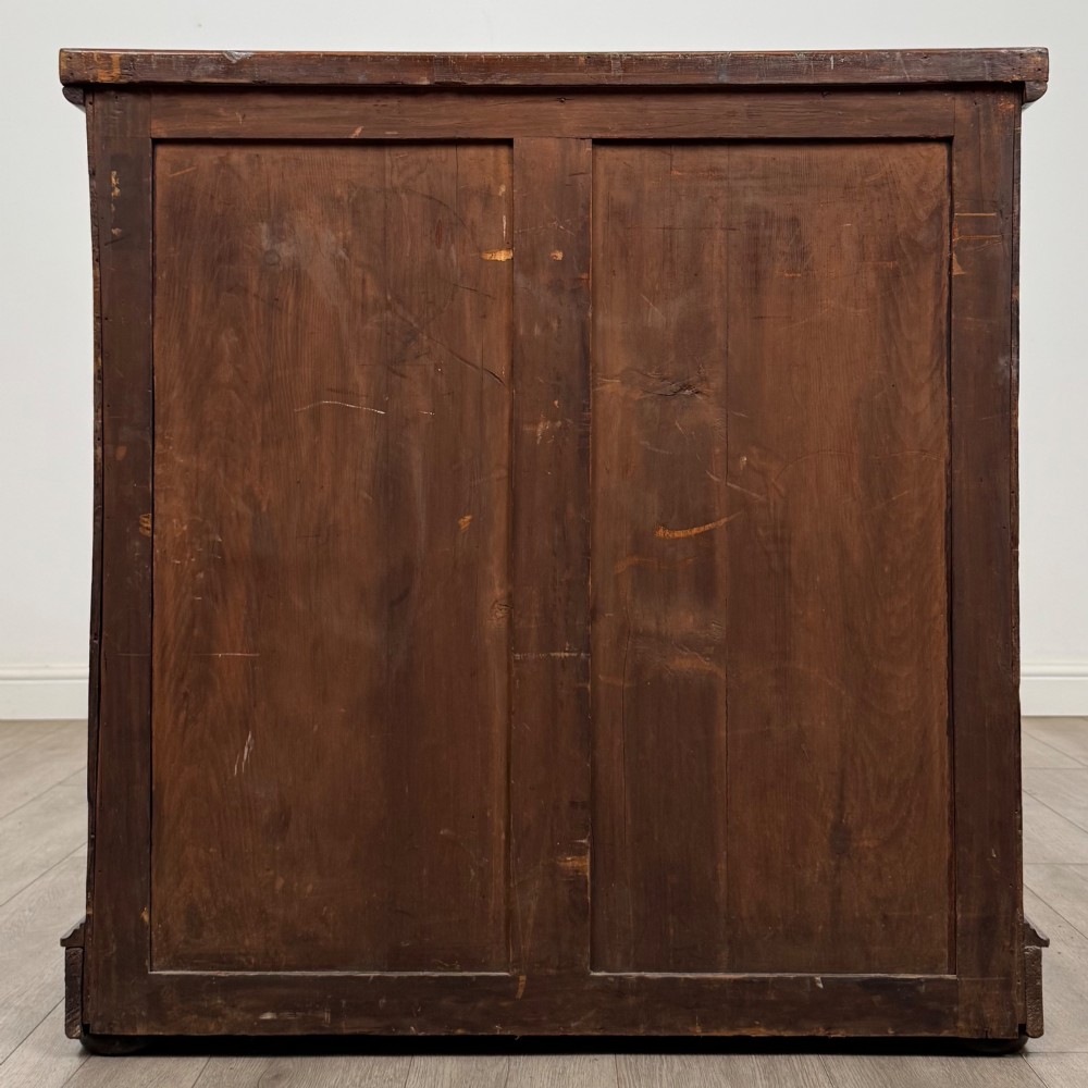 A Victorian dark mahogany chest of drawers featuring two short drawers above two full-width long drawers with turned wooden knobs and a solid plinth base. View V