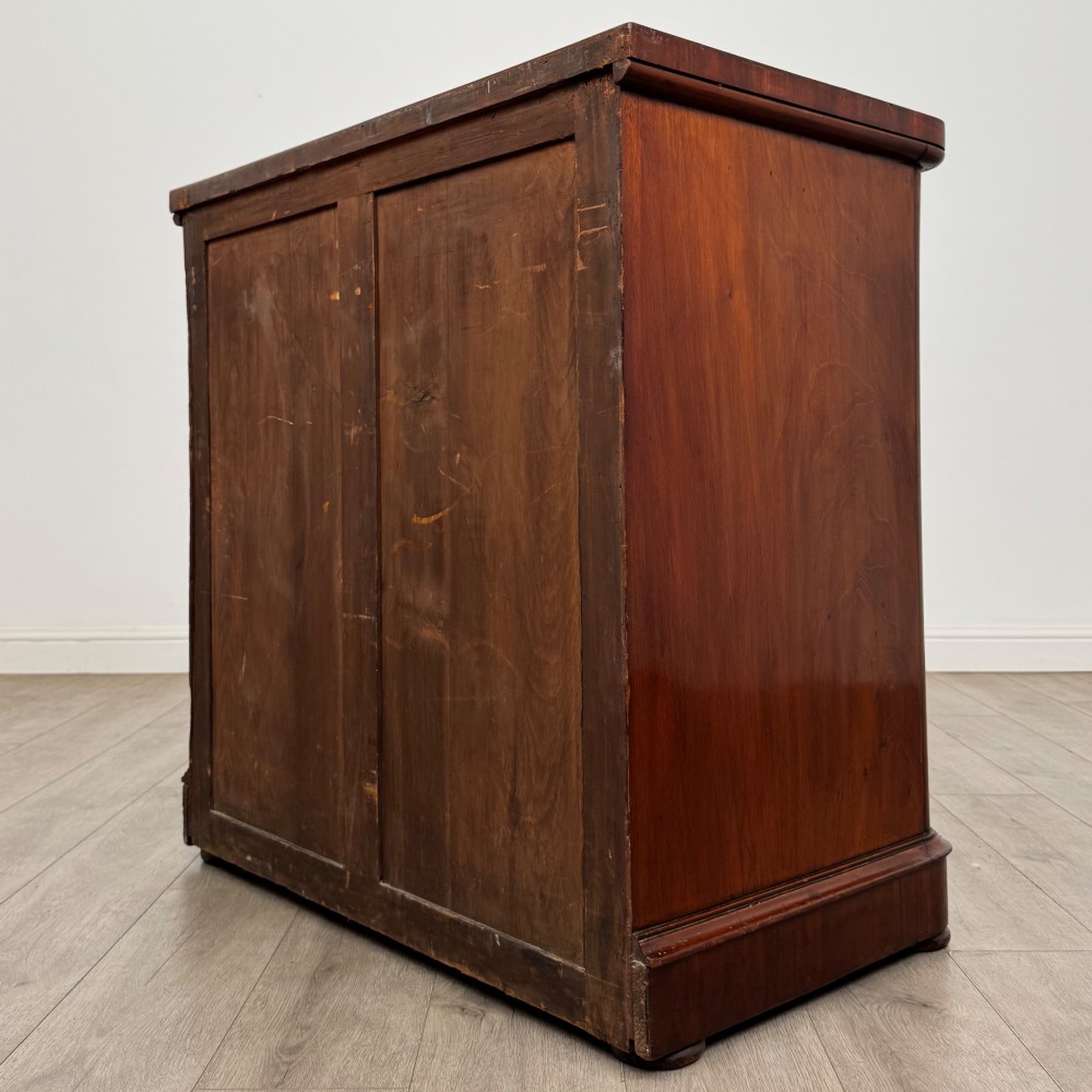 A Victorian dark mahogany chest of drawers featuring two short drawers above two full-width long drawers with turned wooden knobs and a solid plinth base. View VI