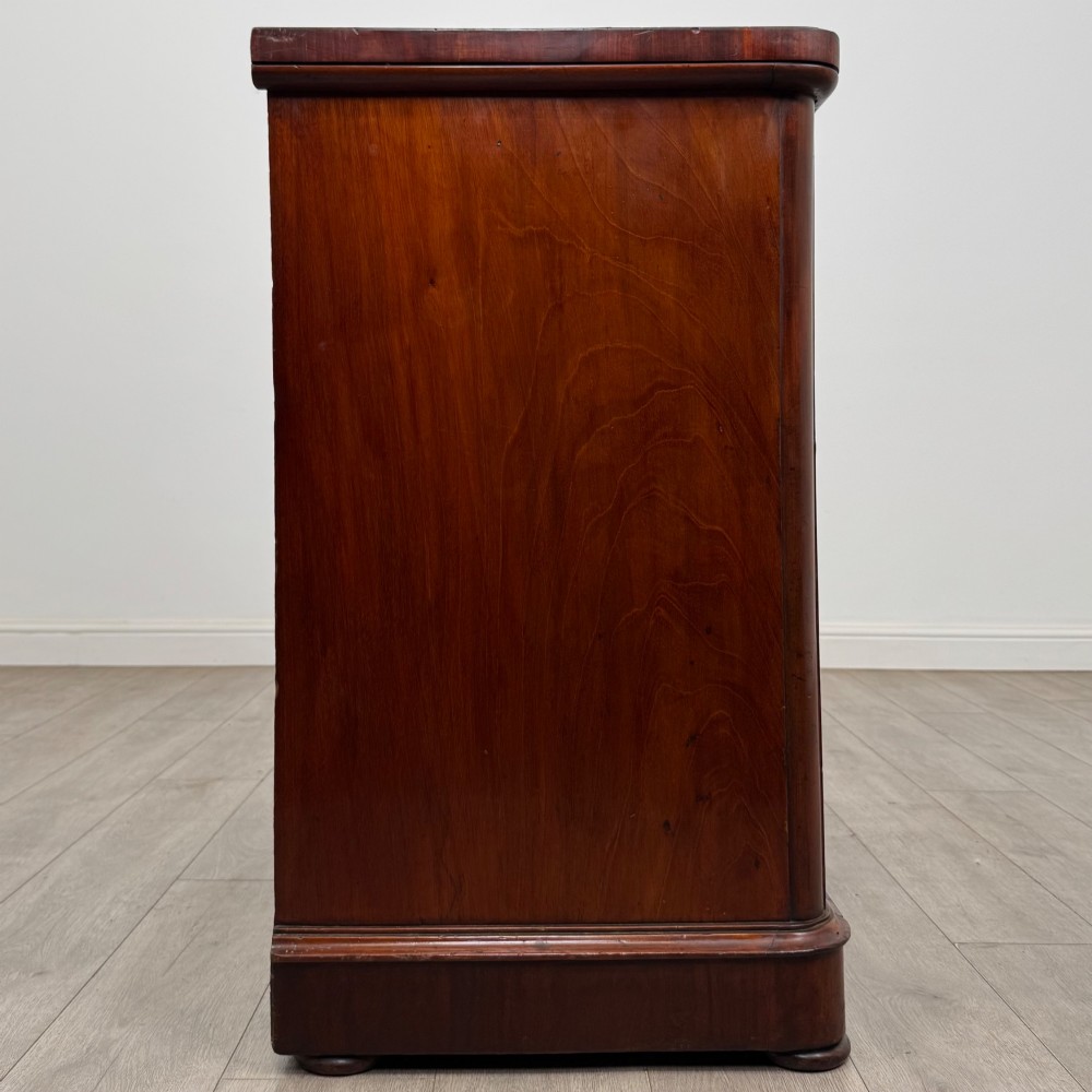 A Victorian dark mahogany chest of drawers featuring two short drawers above two full-width long drawers with turned wooden knobs and a solid plinth base. View VII