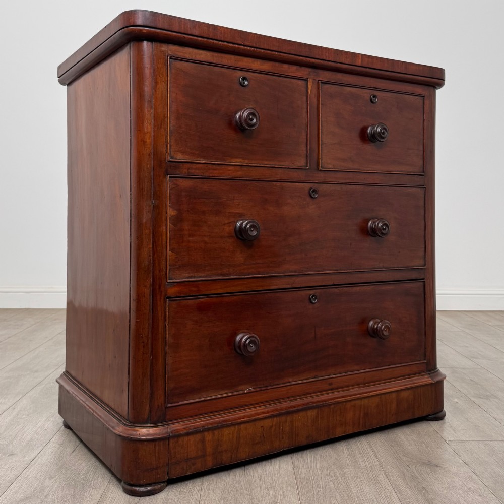 A Victorian dark mahogany chest of drawers featuring two short drawers above two full-width long drawers with turned wooden knobs and a solid plinth base. View VIII
