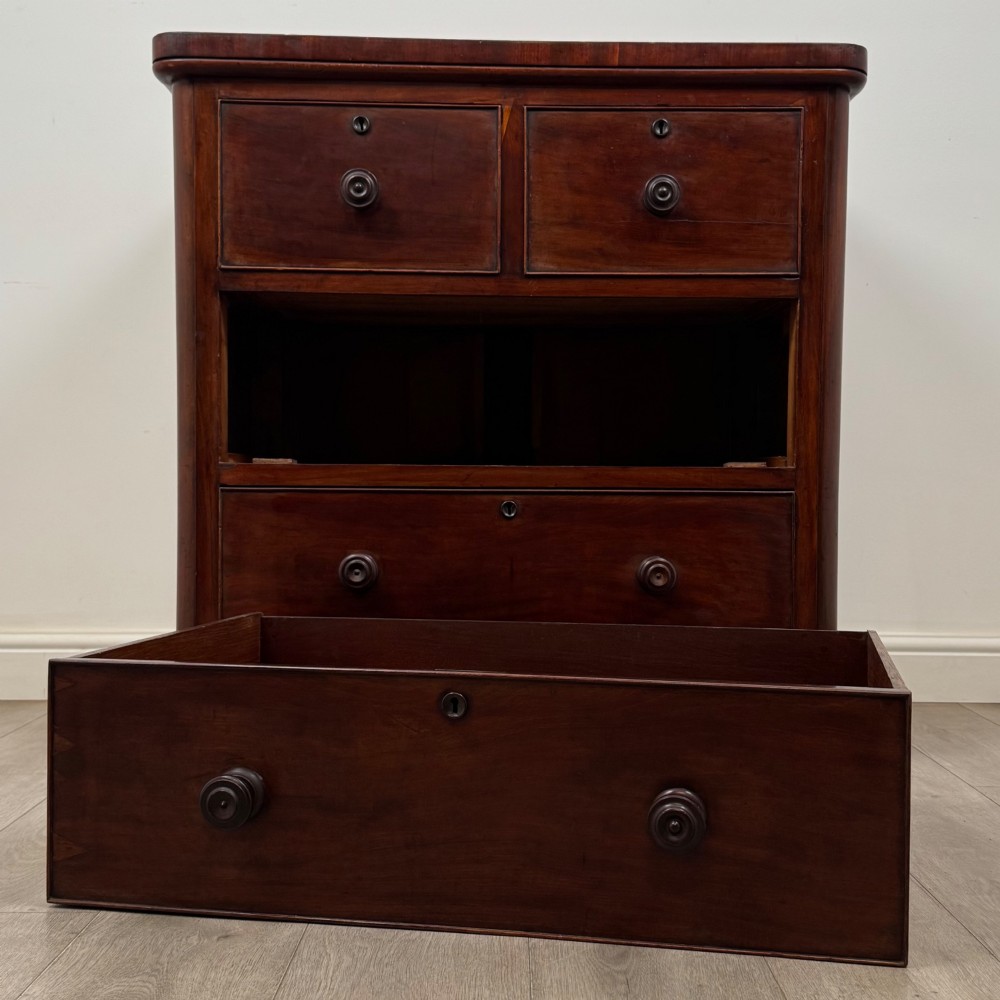 A Victorian dark mahogany chest of drawers featuring two short drawers above two full-width long drawers with turned wooden knobs and a solid plinth base. View X
