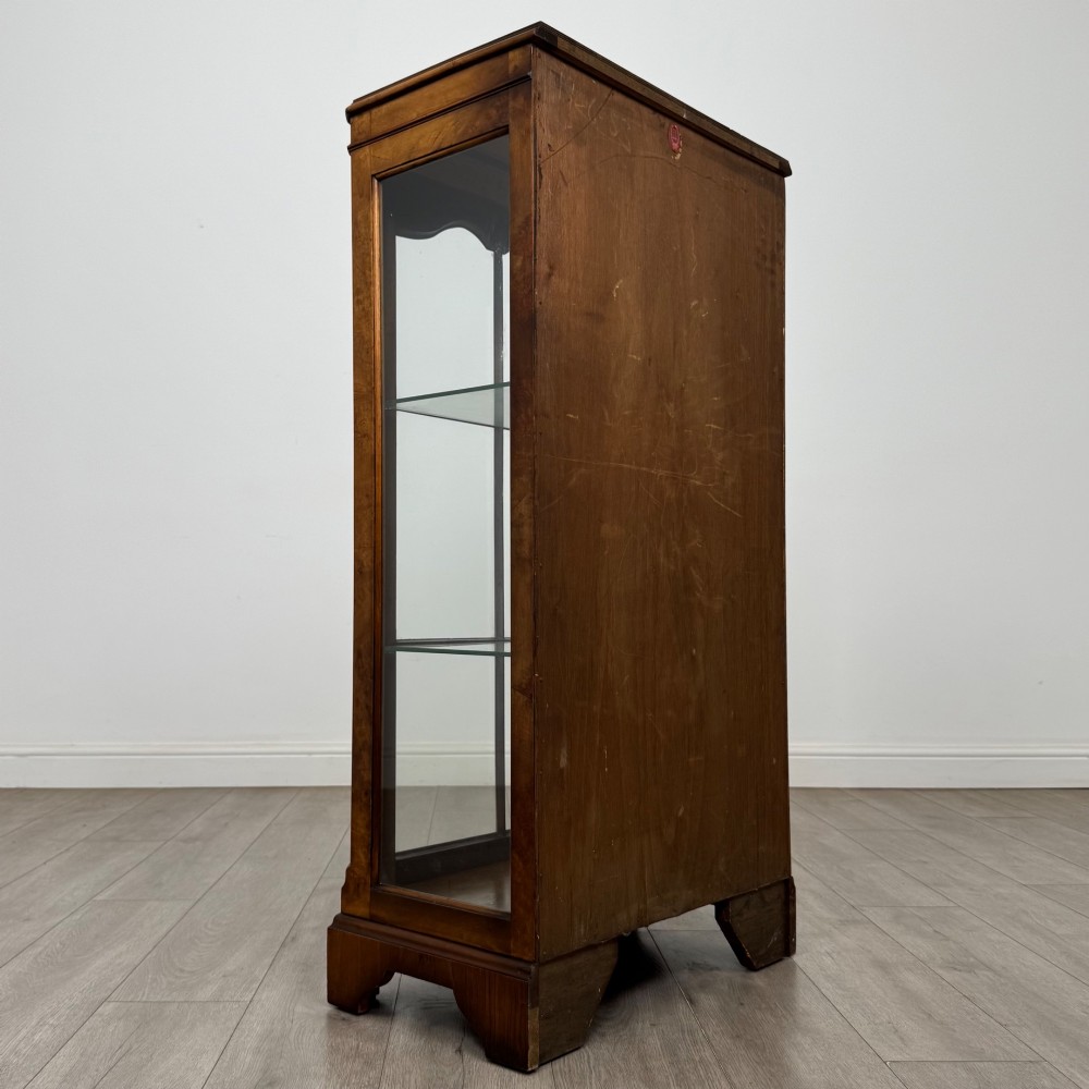 A freestanding burr walnut display cabinet featuring a single glazed door with six glass panes, curved upper frame moulding, and a bracket base. View V