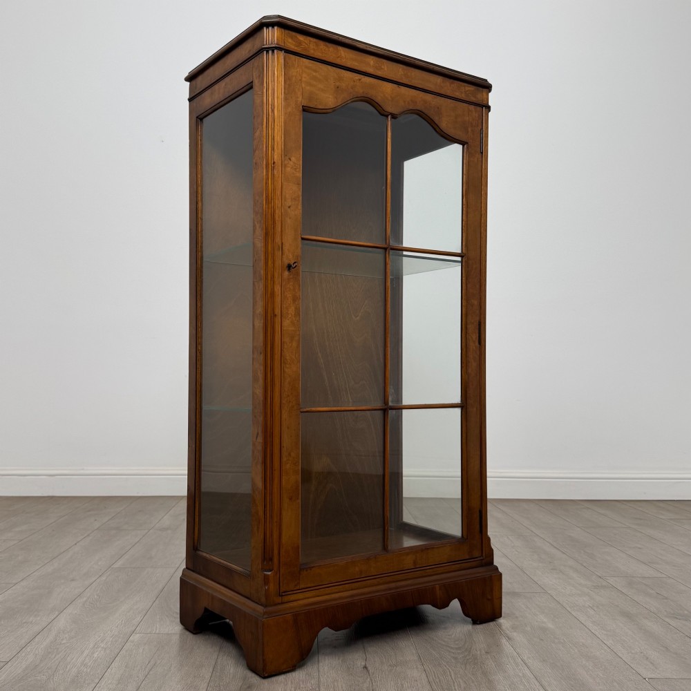 A freestanding burr walnut display cabinet featuring a single glazed door with six glass panes, curved upper frame moulding, and a bracket base. View IX