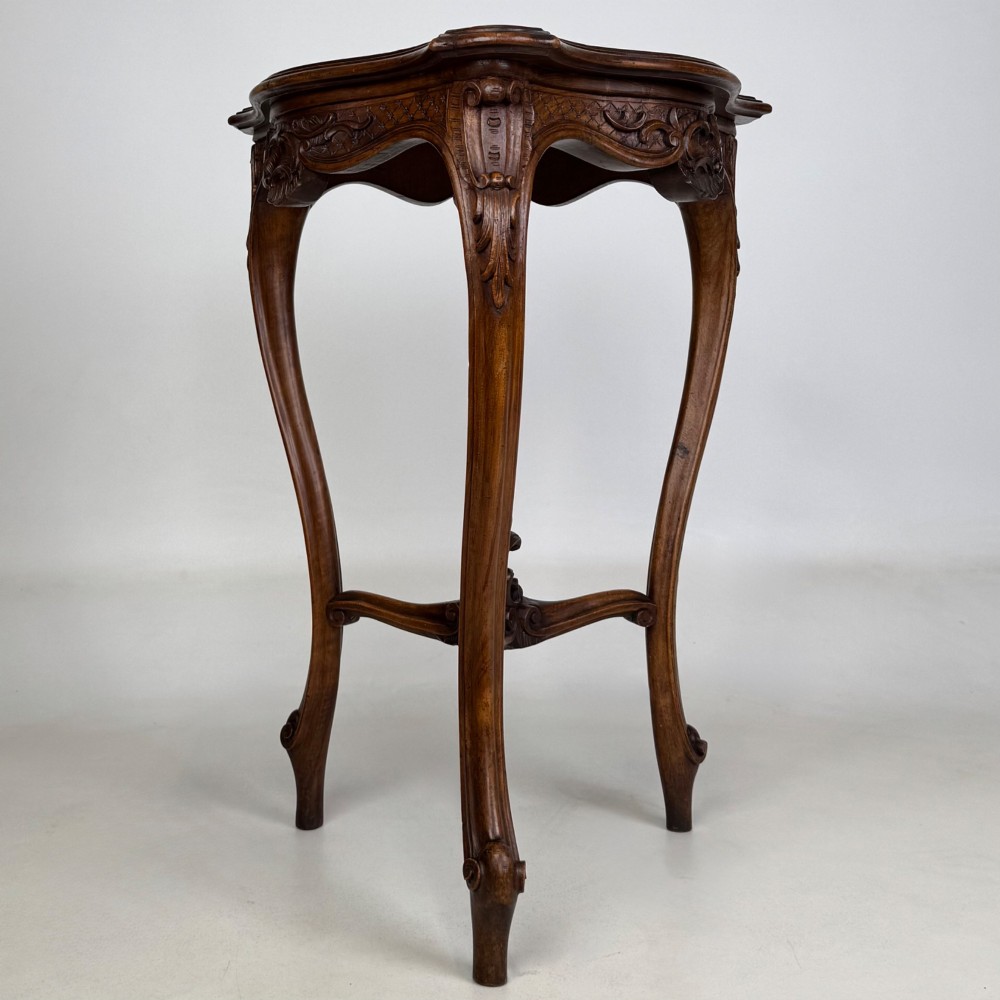 A dark mahogany side table featuring carved cabriole legs, a decorative carved apron with a shell motif, and a sculpted lower cross stretcher. View II