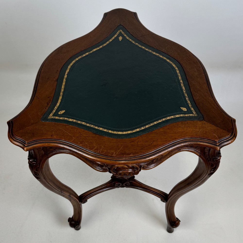 A dark mahogany side table featuring carved cabriole legs, a decorative carved apron with a shell motif, and a sculpted lower cross stretcher. View VI