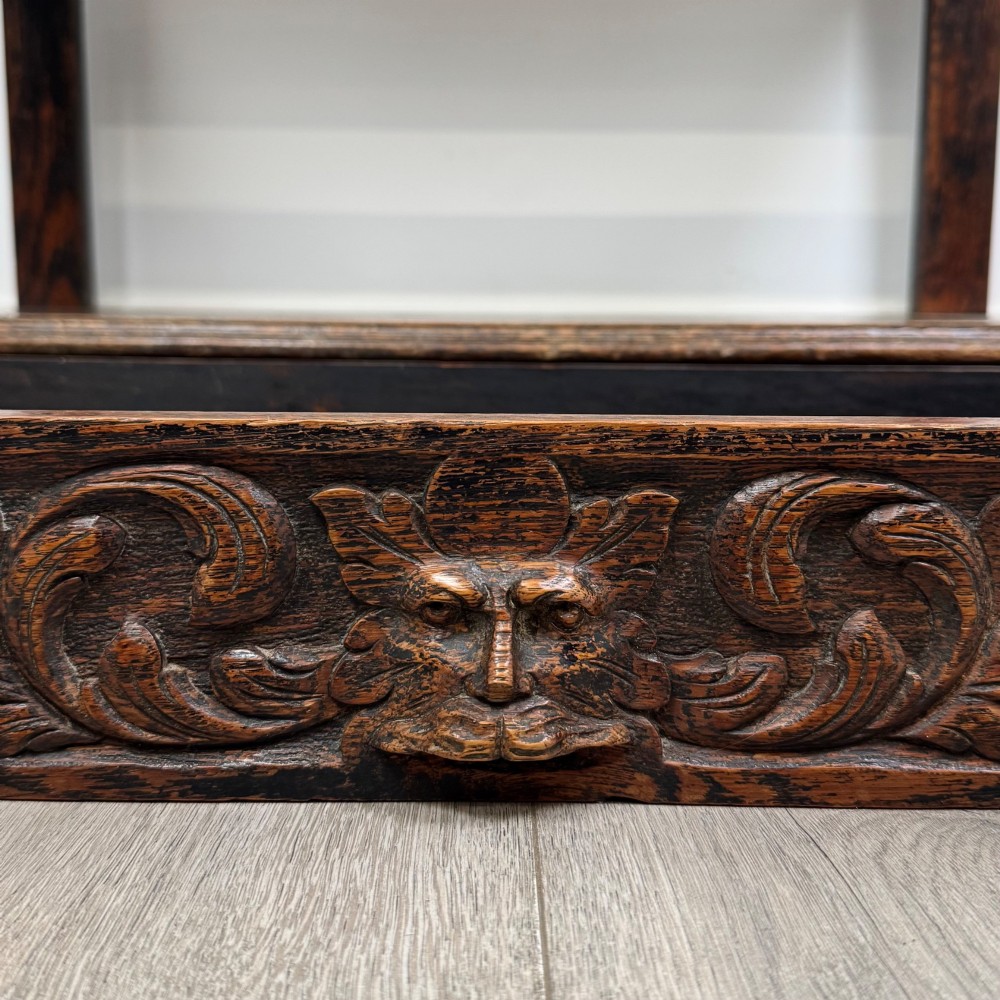 A dark oak Victorian side table featuring bobbin-turned legs, a lower shelf, and a carved frieze with a central mask motif. View XI